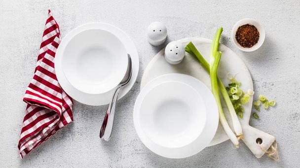 banner of empty white plates on the table served for soup and green onions. healthy kitchen - Valokuva, kuva