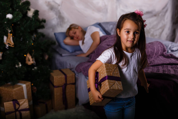 glückliche Familie am Weihnachtsmorgen, Tochter mit Geschenken - Foto, Bild