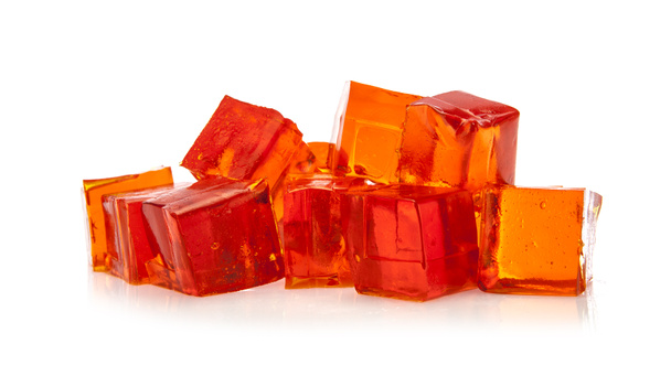 Cubos de gelatina naranja sobre fondo blanco
 - Foto, imagen
