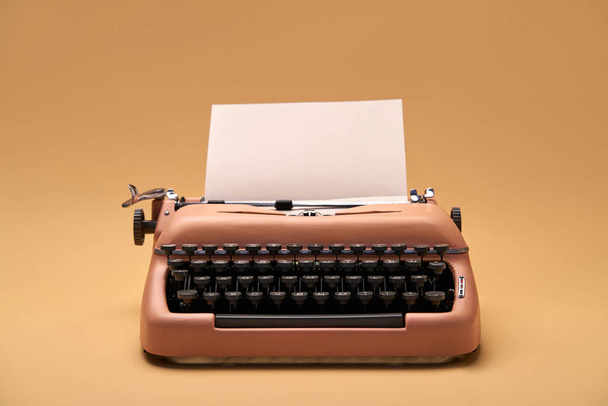 Retro typewriter coral color in studio, studio shoot. - Фото, изображение