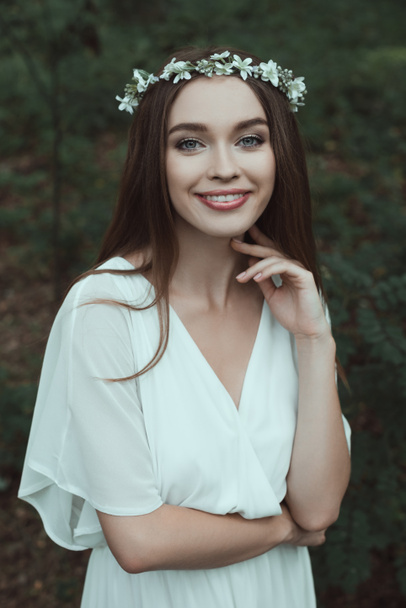 piękne, uśmiechnięte dziewczyny w białej sukni i wieniec kwiatowy - Zdjęcie, obraz