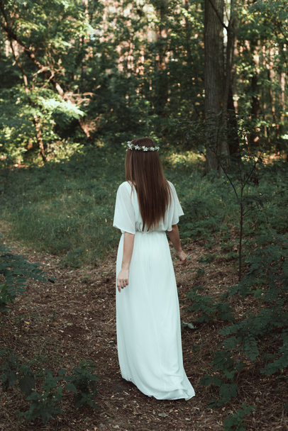 back view of girl in white elegant dress walking in forest  - Foto, Imagem