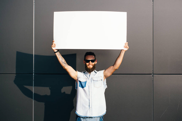 Hipster man holding a poster - Fotoğraf, Görsel