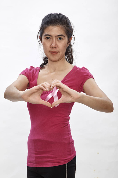 Cinta de mujer con cáncer rosa en el pecho. Concepto de salud, medicina y concienciación sobre el cáncer de mama. Captura de estudio, fondo blanco claro, sistema de salud del seguro
 - Foto, Imagen