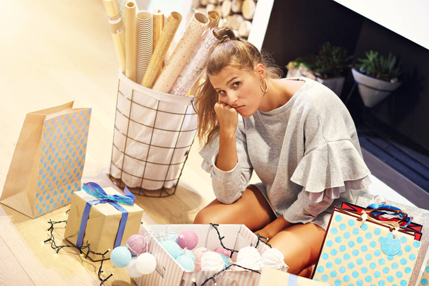 Mujer adulta en casa envolviendo regalos de Navidad
 - Foto, Imagen