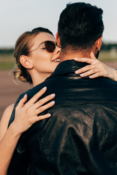 sorrindo mulher atraente abraçando namorado em jaqueta de couro
  - Foto, Imagem