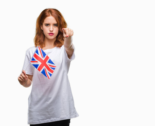 Genç güzel kadın holding bayrağı İngiltere izole arka kamera ve size parmak ile işaret üzerine, el işareti, pozitif ve kendinden emin bir jest ön - Fotoğraf, Görsel