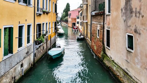 Narrow canal in Venice without sidewalk between the houses - Foto, imagen
