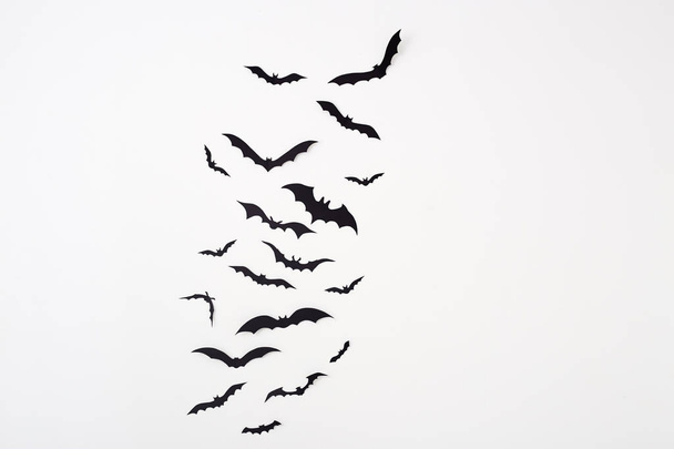Απόκριες και διακόσμηση κενό χώρο για σχεδιασμό αντίγραφο ρυθμό - μαύρο χαρτί νυχτερίδες που πετούν πάνω από το λευκό φόντο - Φωτογραφία, εικόνα