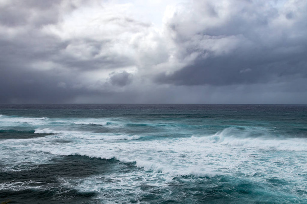 Dunkle Gewitterwolken über rauen Wellen in bedrohlicher Meereslandschaft im offenen Ozean - Foto, Bild