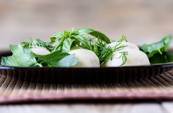 Boiled dumplings on a plate with dill, basil and parsley - Foto, Imagem