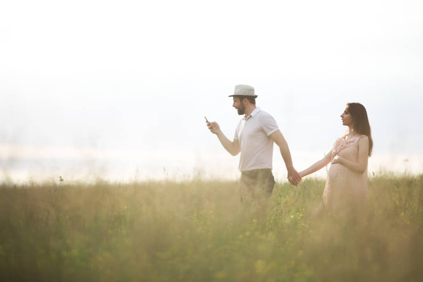 Couple man and pregnant girl in the field - Photo, image