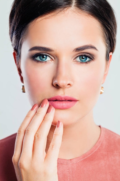 Female face closeup. Gorgeous woman with makeup and manicured hand. Pink lips and nails - Photo, Image