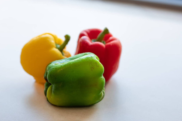 frische grüne, rote und gelbe Paprika auf hellem Hintergrund - Foto, Bild