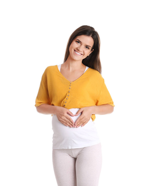 Happy pregnant woman posing on color background - Foto, imagen