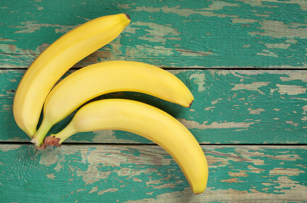 Top view of sweet yellow bananas on a old green wooden background. Space for text - Photo, Image