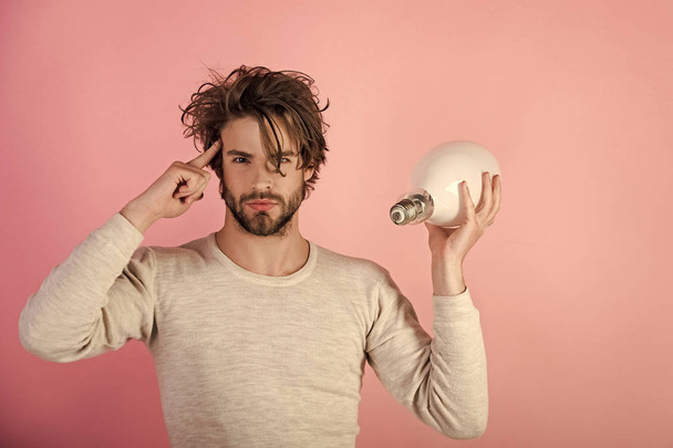 serious guy has an idea on pink background, morning. - Photo, image