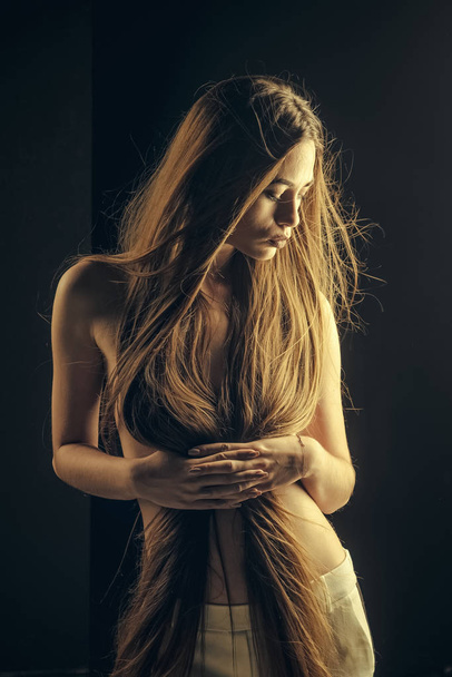 Girl has no makeup and healthy hair on black background. - Foto, afbeelding