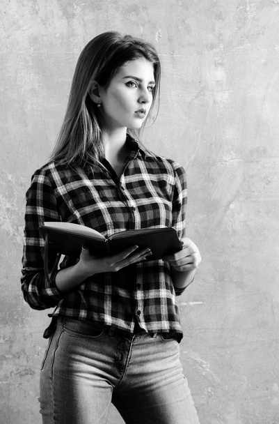 Serious pretty girl or student holding open notebook - Foto, Bild
