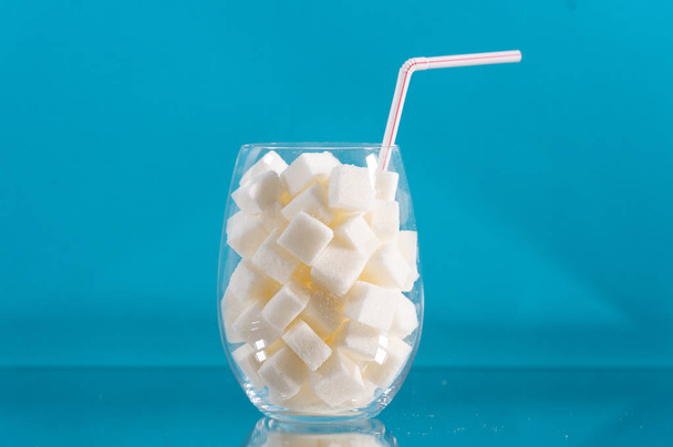 Glass with straw with sugar cubes - Fotoğraf, Görsel