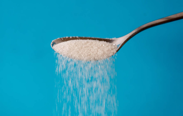 Sugar pouring from a spoon - Фото, зображення
