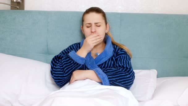 4k kuvamateriaalia nuori sairas nainen flunssa makaa sängyssä ja mitata lämpötilaa
 - Materiaali, video
