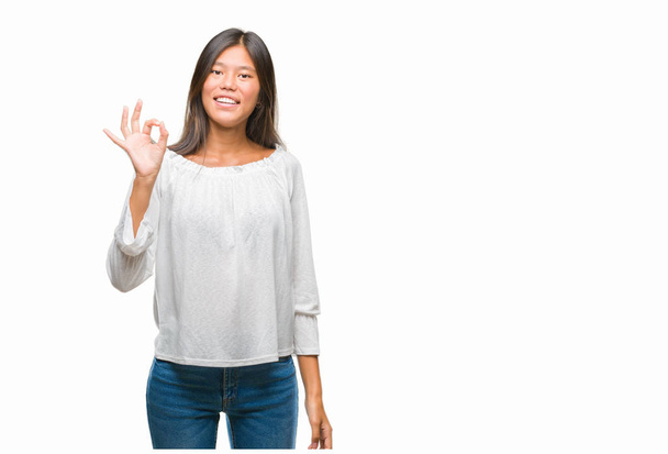 Młode Azjatyckie kobiety na na białym tle tło uśmiechający się pozytywne, robi ok znak z dłoni i palców. Pomyślne wyrażenie. - Zdjęcie, obraz