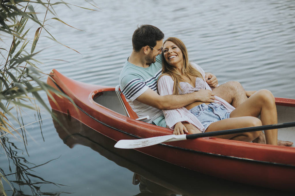 Retrato de cerca de la pareja romántica abrazada paseando en bote por el lago
 - Foto, imagen