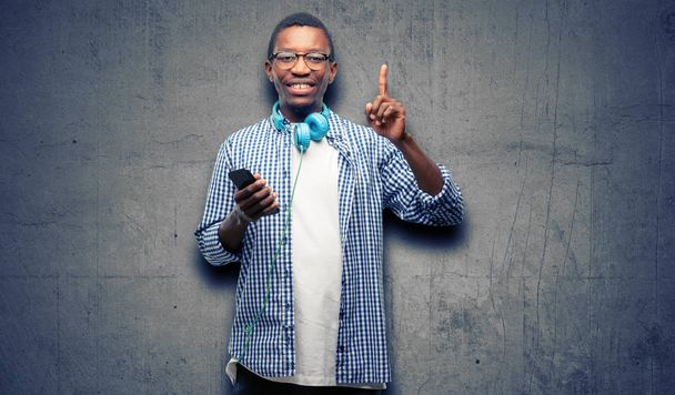 Africké černoch student s smartphone zvyšování prst, číslo jedna - Fotografie, Obrázek