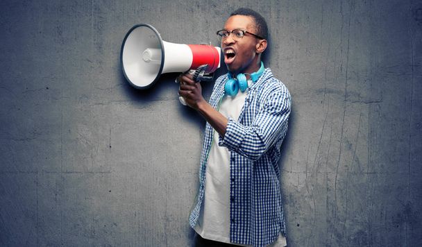 African black man student with smartphone communicates shouting loud holding a megaphone, expressing success and positive concept, idea for marketing or sales - Photo, Image