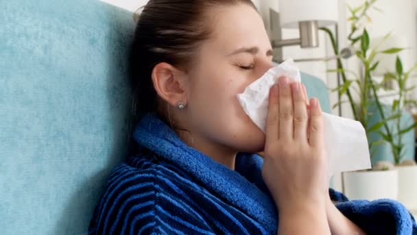 Closeup 4k video van jonge zieke vrouw haar neus blazen en het gebruik van neusspray - Video