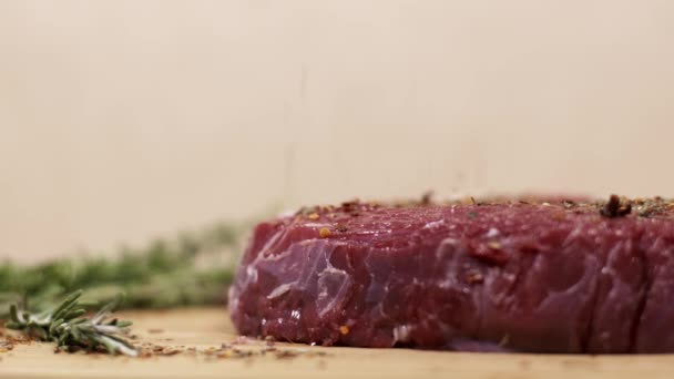Gotas de condimento en trozo de carne de res roja fresca cruda en la mesa
 - Imágenes, Vídeo