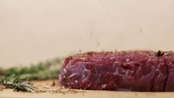 Especias que caen en trozo de carne roja fresca cruda en la mesa
 - Metraje, vídeo