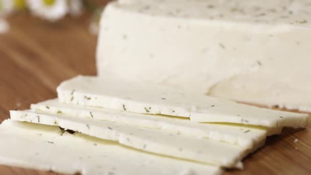 Lekkere witte cottage cheeze met kruiden wordt gesneden met mes op snijplank - Video