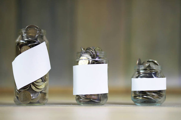 Accumulated coins stacked in glass jars - Photo, Image