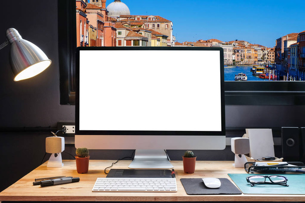 Espacio de trabajo del diseñador gráfico con una tableta de lápiz, una computadora y un fondo blanco para texto con hermosa vista de Venecia desde la ventana
 - Foto, Imagen