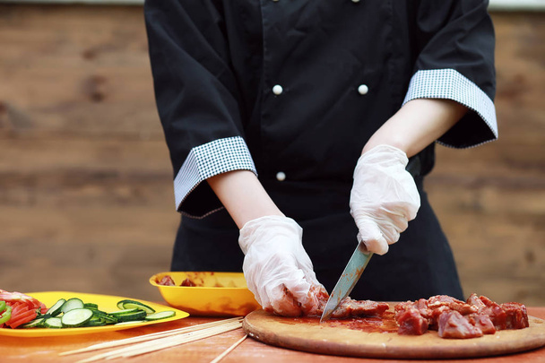 Кухар розрізає м'ясо для приготування барбекю
 - Фото, зображення