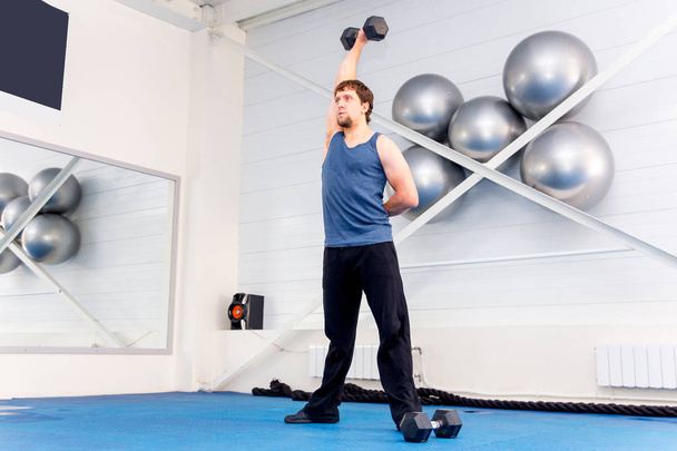 Young muscular man doing crossfit exercises in a gym - Photo, image