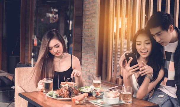 Asian single woman envious with love couple doing take selfie at restaurant. - Photo, Image