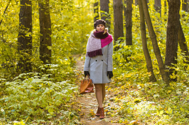 Νεαρή γυναίκα κομψό περπάτημα στο πάρκο φθινόπωρο - Φωτογραφία, εικόνα