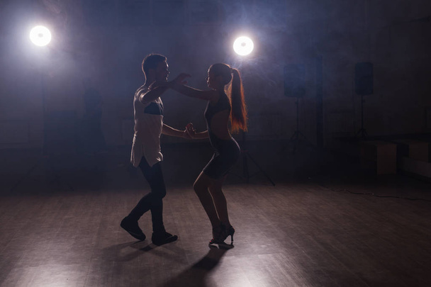 Молода пара танцює соціальну танцювальну тарілку або бачату або сему або такуксію на фоні танцювального класу
 - Фото, зображення
