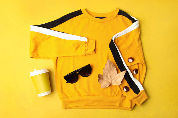 Sonbahar kazak, güneş gözlüğü ve turuncu bir arka plan üzerinde kahve. Kavram sonbahar kıyafetleri - Fotoğraf, Görsel