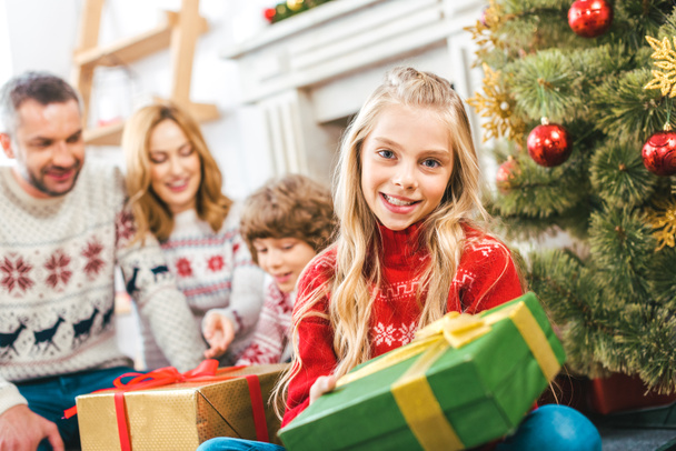 beautiful little child with present spending time with brother and parents on christmas at home - 写真・画像