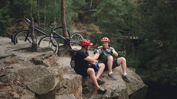 Motosiklet çam ormanı ile kayaya dinlenme sırasında elele kask içinde deneme motorcu - Video, Çekim