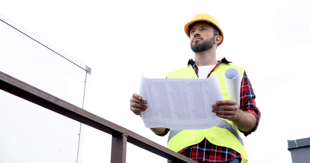 architect in helmet and safety vest checking blueprints - Footage, Video