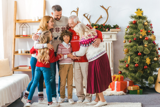 glückliche Familie, die sich zu Weihnachten zu Hause umarmt - Foto, Bild