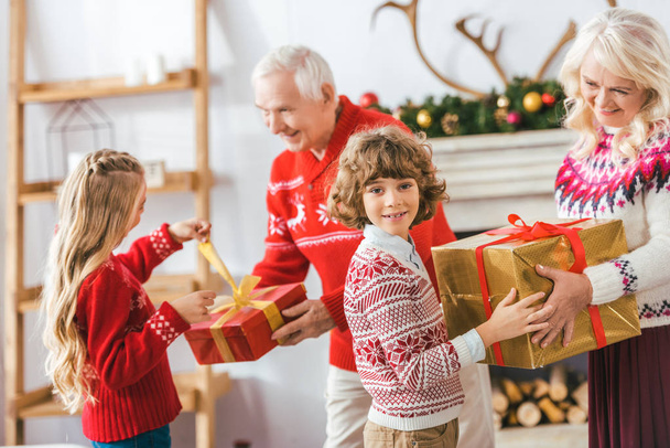 grandparents and happy kids with gift boxes spending time together on christmas - Fotografie, Obrázek