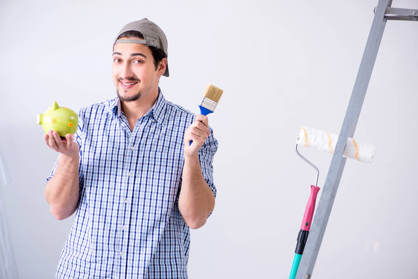 Молодой художник делает ремонт дома  - Фото, изображение