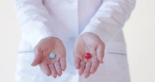 περικοπεί shot του γιατρού κρατώντας κόκκινα και άσπρα χάπια σε λευκό - Πλάνα, βίντεο