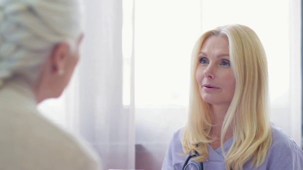 mosolygó női orvos beszél a vezető beteg - Felvétel, videó